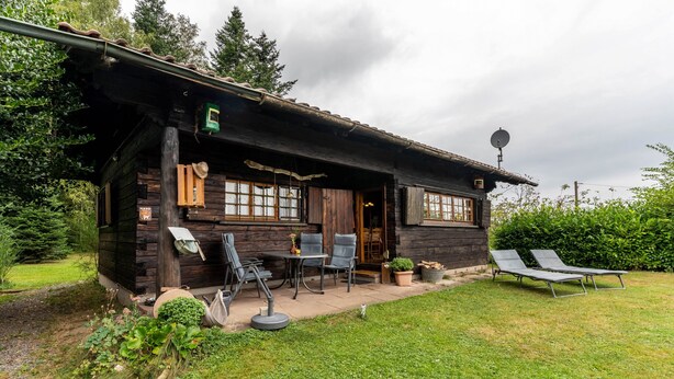 A rustic wooden cabin with a patio, outdoor seating, and a satellite dish. - Holiday Home 'Blockhaus Paepke' with Private Terrace and Private Garden (Mühlenbach)