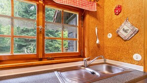 A kitchen with a window, sink, and wooden wall. - Holiday Home 'Blockhaus Paepke' with Private Terrace and Private Garden (Mühlenbach)