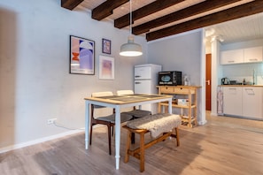 Une cuisine moderne équipée d’un réfrigérateur, d’un four à micro-ondes et d’une table en bois avec des chaises.