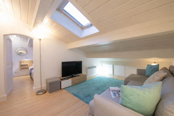 A modern loft bedroom with a skylight, a flat-screen TV, a sofa, and a bedside table. - La Verte 27 Ski In/Ski Out | Grands Montets | Argentière Chamonix, Argentière (Chamonix), France (Argentière (Chamonix))