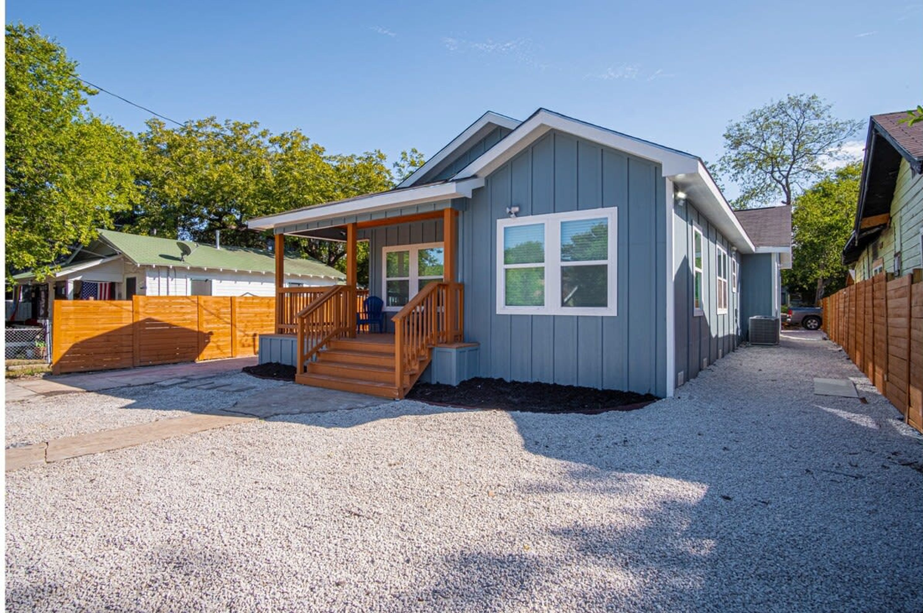 Einbungalow mit Veranda, Eingangstür und einer kurzen Auffahrt.
