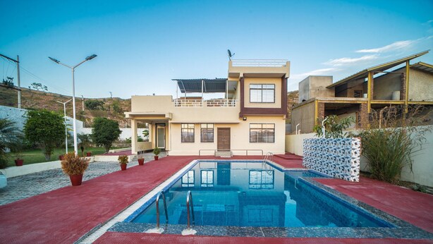 A modern house with a swimming pool, a red tiled patio, and a balcony. - The Ekling Villa (Udaipur)