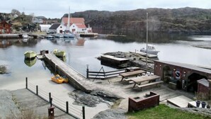Un port avec des bateaux, un quai et un bâtiment doté d’un toit rouge.