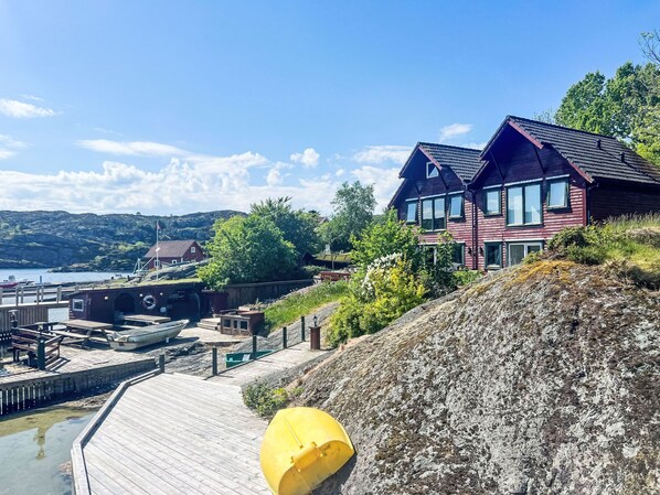 A waterfront property with a wooden dock, a yellow buoy, and a large house with a steep roof. - Kalavåg by Interhome (Langevåg)