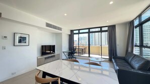 A modern living room with a flat-screen TV, a dining area with a marble table, and a black leather sofa. - MetaWiseBnB|Sydney CBD|Chinatown|Luxe 2Bed Penthouse Bella (Haymarket)