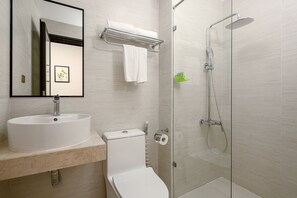 A modern bathroom with a sink, toilet, and glass-enclosed shower. - Doji Stars (Da Nang)
