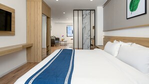 A modern hotel room with a large bed, wooden wardrobe, a small desk, and a television. - Doji Stars (Da Nang)
