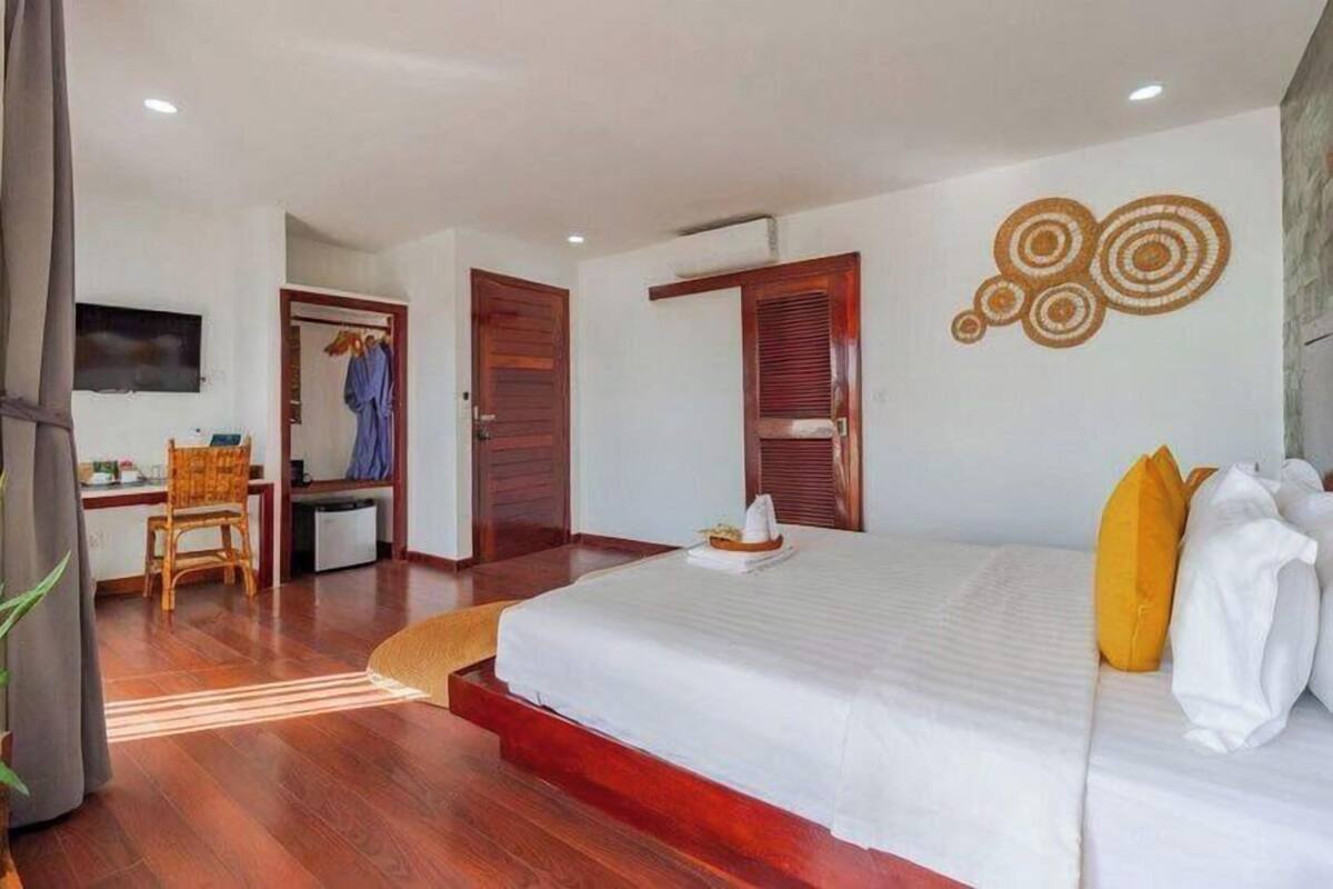 Une chambre d’hôtel avec un grand lit, un bureau et une télévision.