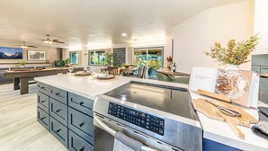 A modern kitchen with a large island, built-in appliances, and a dining area with a view. - Starry Night Cabin at Sky Ranch (Oakhurst)