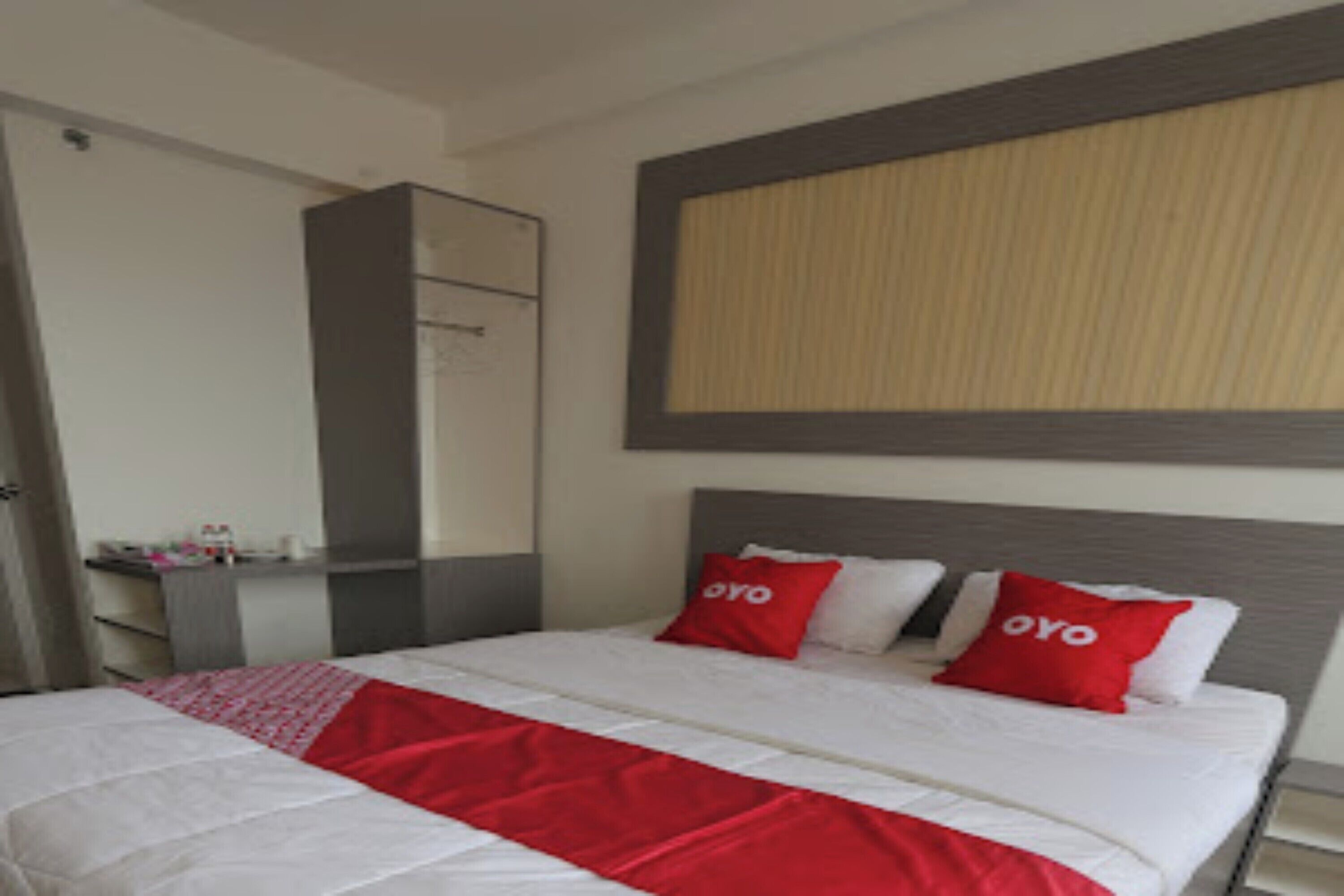 A hotel room with a bed, a wardrobe, and a mirror.