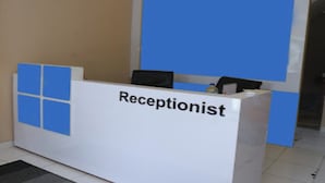 A reception desk with a sign that reads "Receptionist." - OYO Life 92859 Biant House (Cikarang)