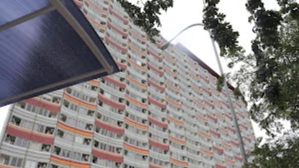 A multi-story residential building with balconies, parked cars, and trees in front. - OYO Life 92859 Biant House (Cikarang)