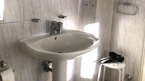 A bathroom with a white sink, a mirror, and a small white stool. - Large apartment with 2 bathrooms and 2 large parking spaces (Leichlingen (Rheinland))