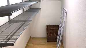 A storage room with metal shelves, a radiator, and a wooden floor. - Large apartment with 2 bathrooms and 2 large parking spaces (Leichlingen (Rheinland))