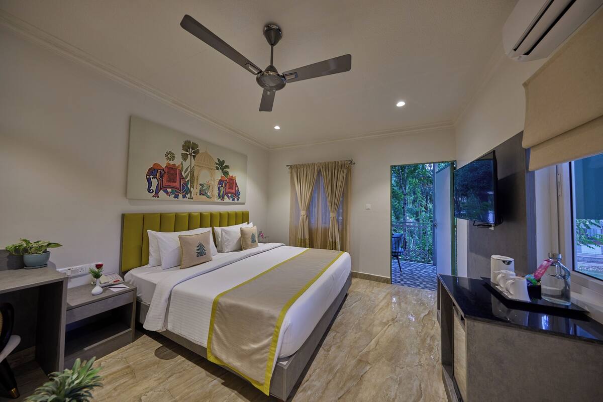 A hotel room with a bed, desk, and TV.