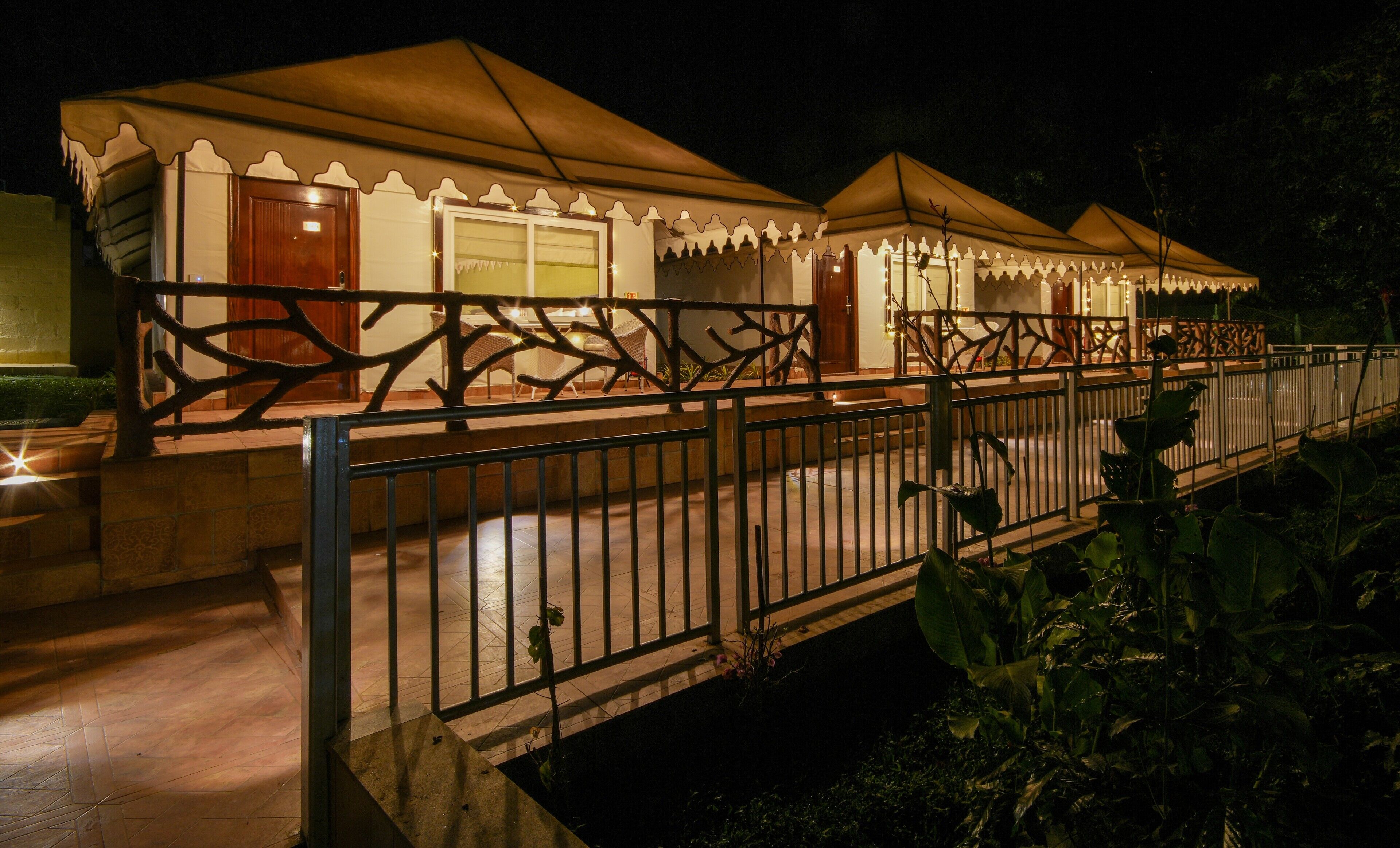 A series of tents with a decorative metal fence in front.