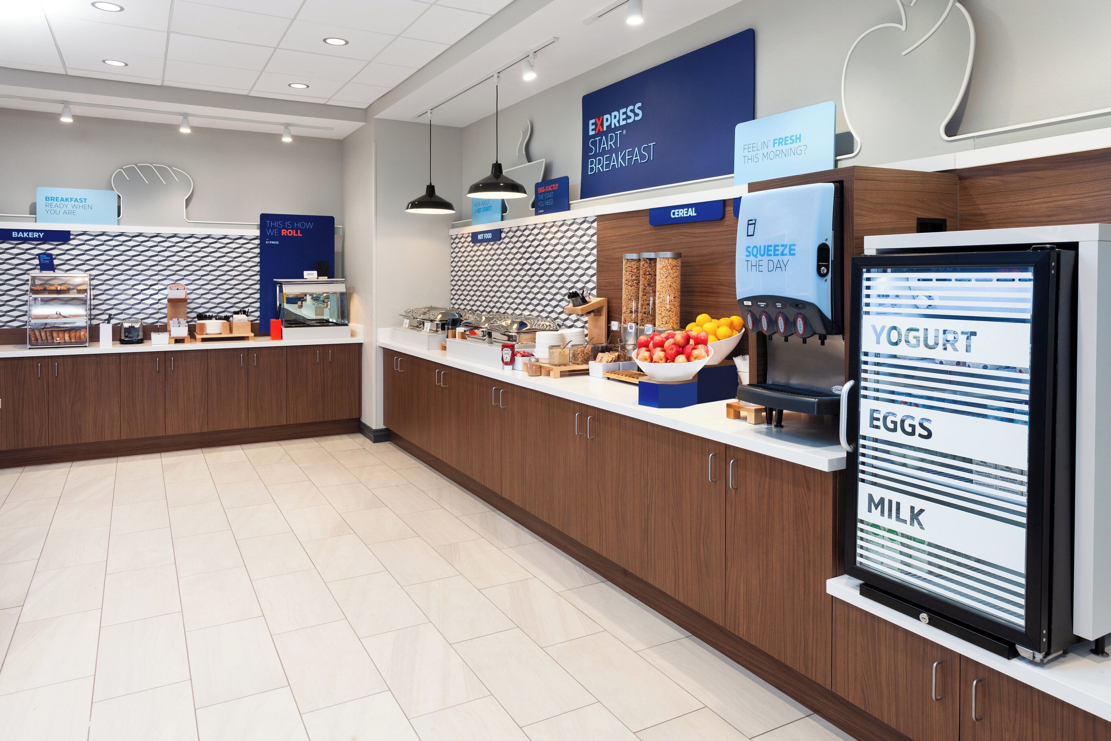 A modern breakfast area with a self-serve station, a yogurt dispenser, and a variety of food items.