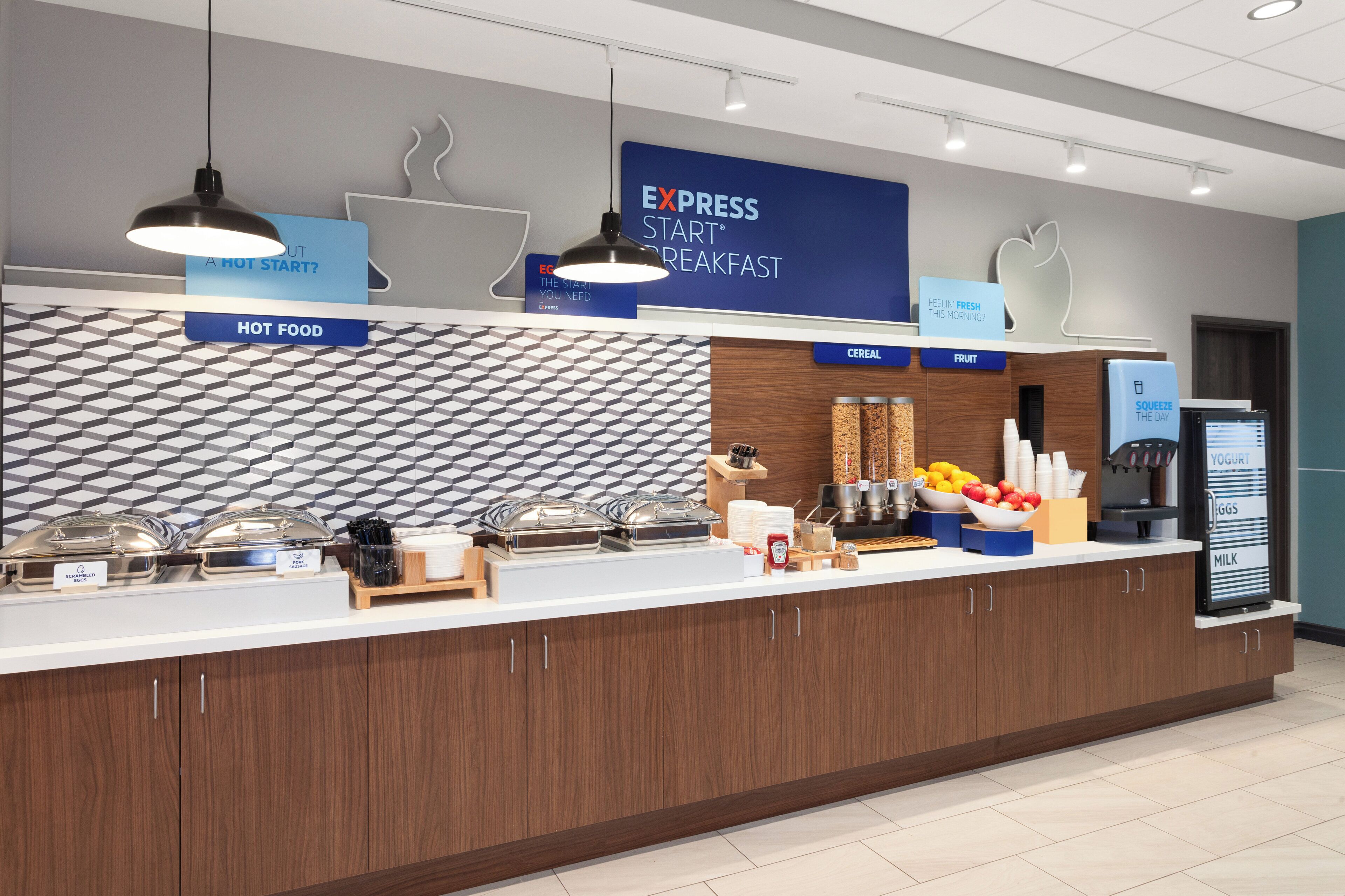 A breakfast bar with labeled sections for hot food, cereal, fruit, and yogurt.