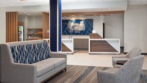 A lobby with a reception desk, a sofa, and a chair. - Holiday Inn Express & Suites Reedsburg - Dells Area by IHG (Reedsburg)