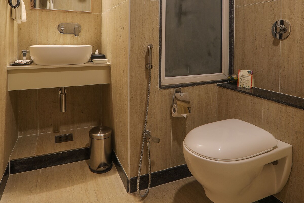 A modern bathroom with a sink, mirror, and toilet.