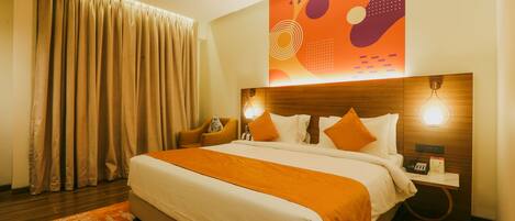 A hotel room with a large bed, a nightstand, a lamp, and a wall with abstract art.