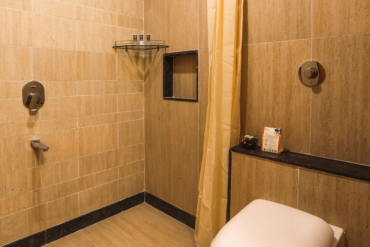 Un baño con ducha, inodoro y un estante con artículos de aseo.