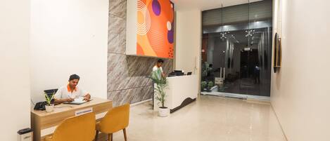 A reception area with a desk labeled "Duty Manager," a reception counter, and a glass door leading to a hallway.