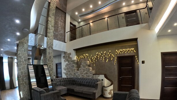 A spacious living area with a sectional sofa, a flat-screen TV, and a stone accent wall.