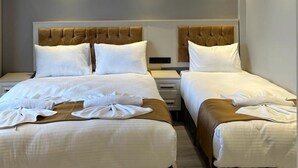 A hotel room with two beds, each with a headboard, white bedding, and a small bedside table. - Sareban Hotel Istanbul  (Istanbul)