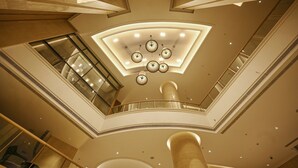 A multi-level atrium with a central skylight, glass railings, and a modern chandelier. - LYFE Hotels Bhubaneswar  (Bhubaneshwar)