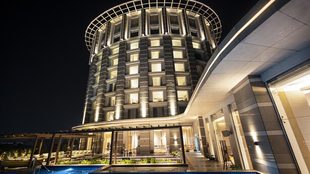 A modern hotel with a pool, featuring a cylindrical tower and a curved facade. - LYFE Hotels Bhubaneswar  (Bhubaneshwar)