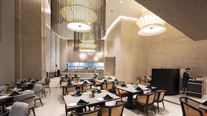 A spacious restaurant with high ceilings, modern chandeliers, and a clean, elegant interior. - LYFE Hotels Bhubaneswar  (Bhubaneshwar)