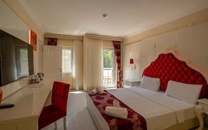 A hotel room with a large bed, a TV, a desk, and a chair.