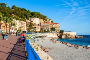 A coastal hotel with a beach view, multiple floors, and a prominent building with a red roof. - Historic Heart: Luxury Suite 100 Meters From the Beach. Rooftop Views.2-4 People (Nice)