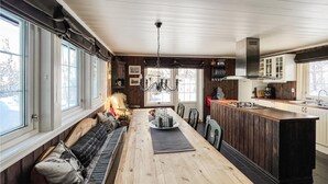 A cozy kitchen with a wooden dining table, a built-in bench, and a large window.