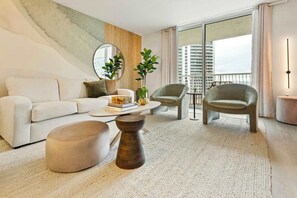 Una sala de estar moderna con un sofá, dos sillones, una mesa de centro y un espejo grande.