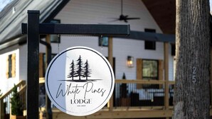 Un panneau circulaire portant le logo et le nom de White Pines Lodge, établissement fondé en 2023.