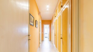 A hallway with a light-colored floor and walls painted in a warm yellow tone.