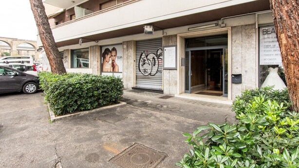 A building with a storefront, a closed shutter, and a signboard.