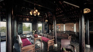 Un interior tradicional con muebles de madera, un banco rojo y una mesa de comedor con fruta.