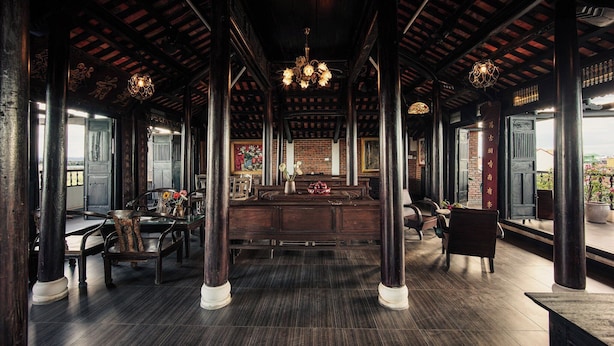 Un interior tradicional con suelos de madera oscura, una recepción central y una araña.