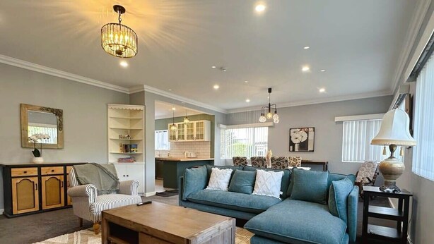 A living room with a sofa, armchair, coffee table, and a rug. - SandyBay Garden Hideaway (Sandy Bay)