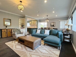 A living room with a sofa, armchair, coffee table, and a rug. - SandyBay Garden Hideaway (Sandy Bay)