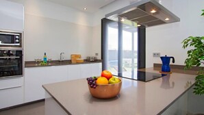 A modern kitchen with a central island, a microwave, and a kettle. - Villa Zanata with air conditioning and hot tub (Puerto del Carmen)