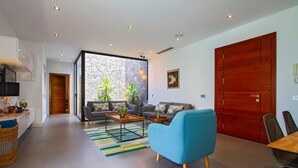 A modern living room with a sofa, armchair, coffee table, and a dining area with a table and chairs. - Villa Zanata with air conditioning and hot tub (Puerto del Carmen)
