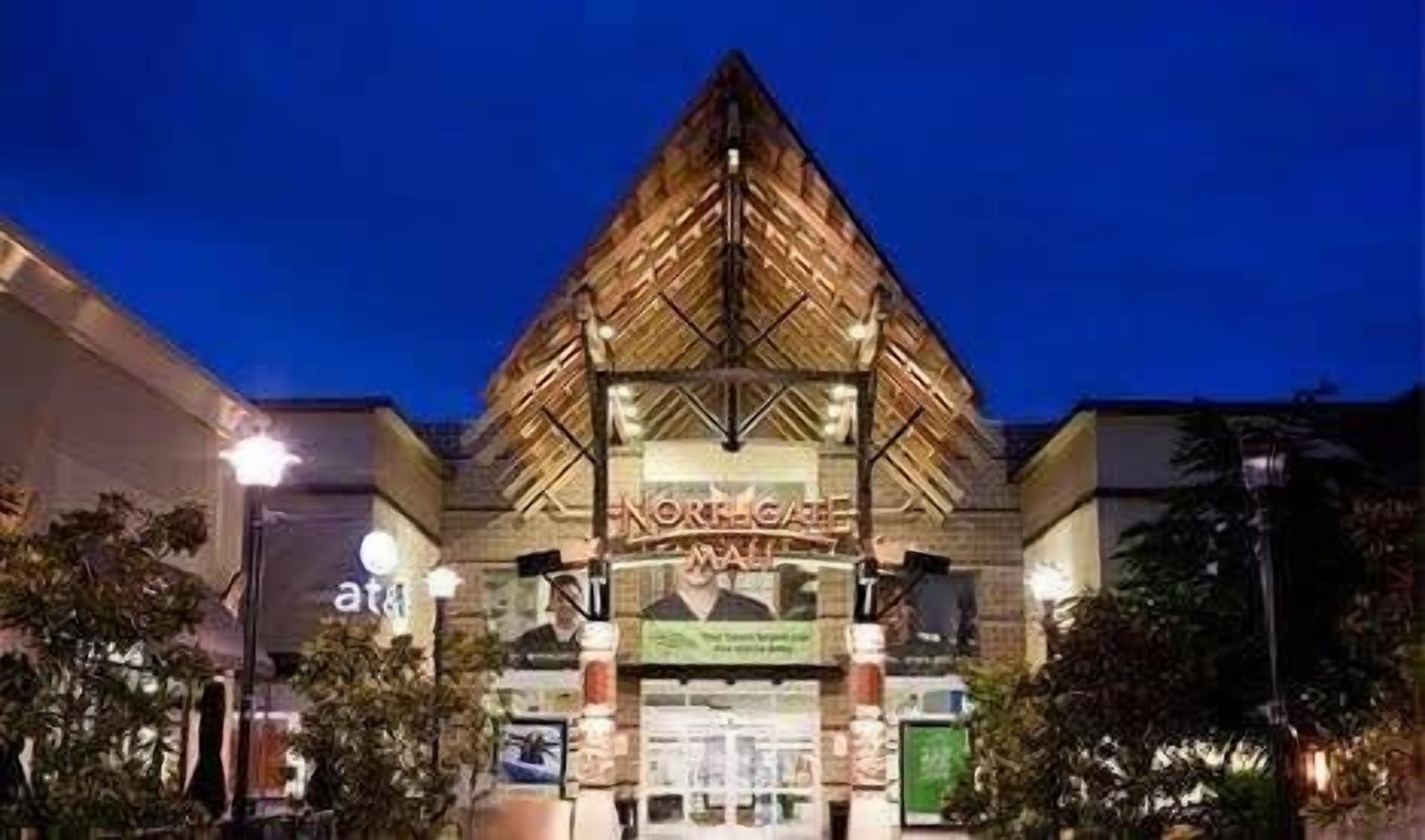 Entrada de un hotel con un techo distintivo en forma de pirámide y un cartel que dice 'Northgate Mall'.