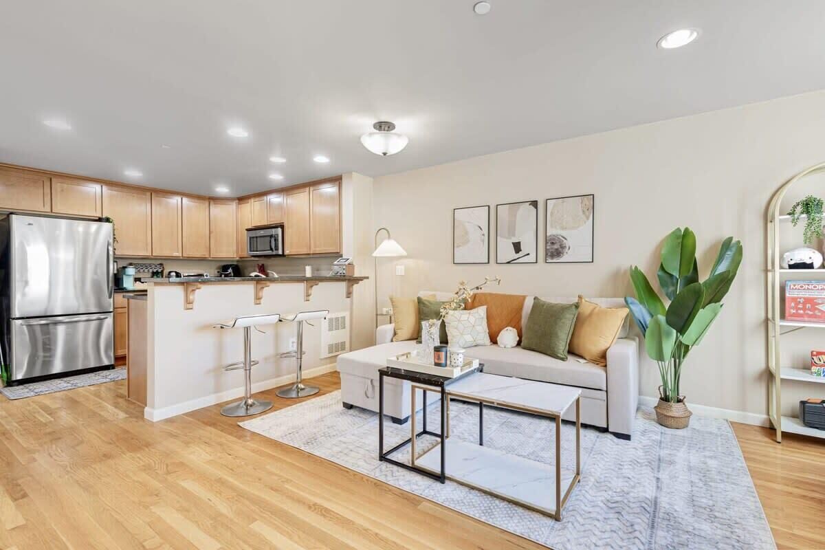 A modern kitchen with stainless steel appliances, a central island, and a bar stool.