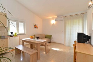 Cozy living space with a dining table, sofa, and kitchenette.