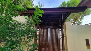 A wooden gate with vertical bars, leading to a covered entrance with a tiled floor. - Private Pool Villa · Kantiang Bay Sea Views · Koh Lanta (Koh Lanta)