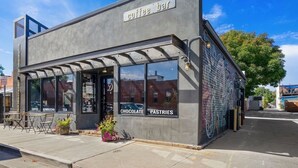 A coffee bar with a modern design, featuring large windows and a signboard displaying the name and services offered. - Lil' Love Shack ~ Private Yard (Loveland)